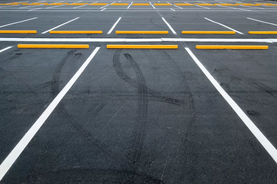 Empty asphalt parking lot with white lines.